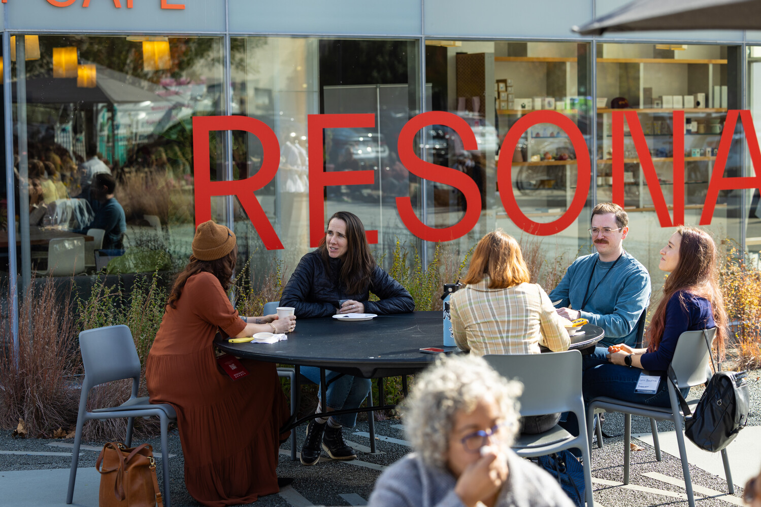 Attendees chatting at an outdoor cafe table